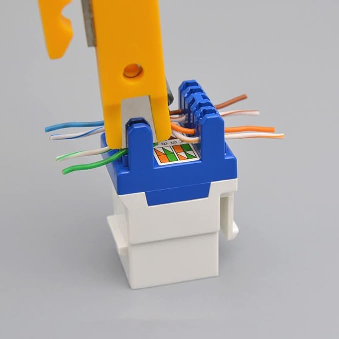 Keystone Jack UTP Cat6 IDC being terminated with a tool, showing color-coded wires for network data connection.